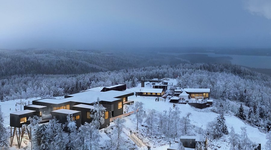 Winter lodge buildings in snow above a lake